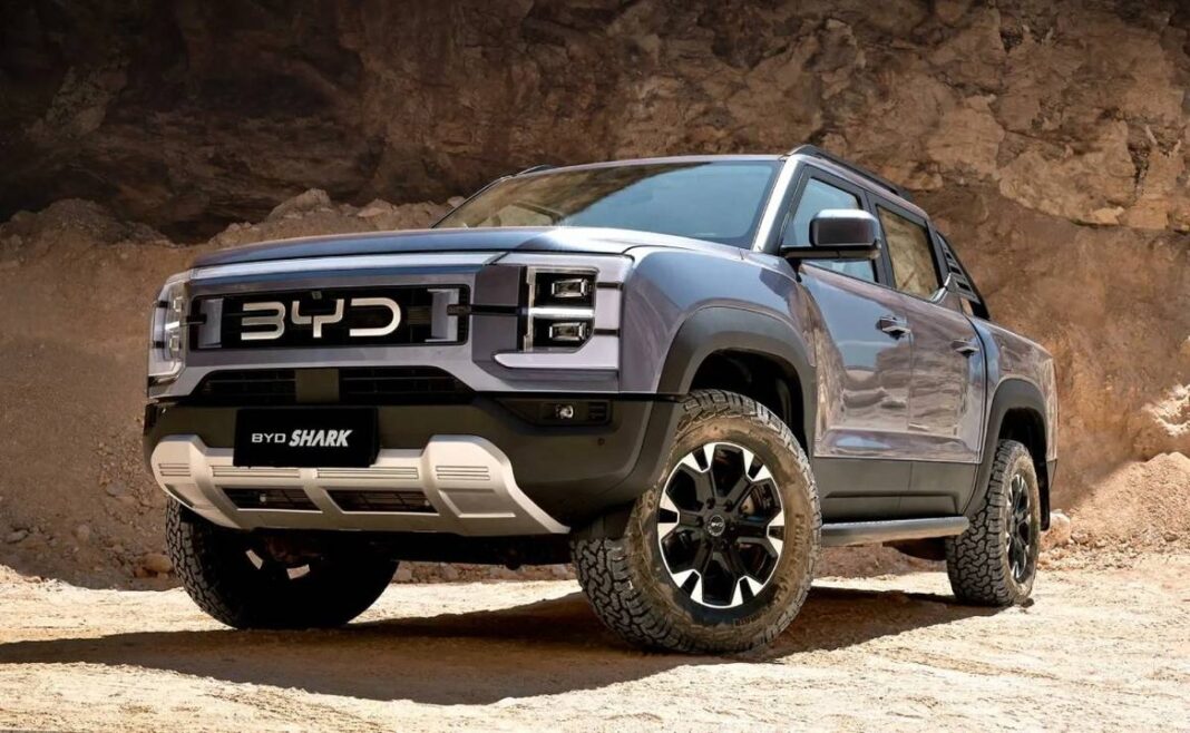 BYD Shark, pick-up híbrida de color gris, vista frontal y lateral en ruta