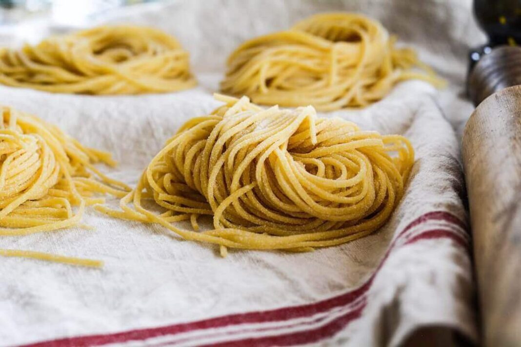 Paquete de pastas sobre una mesa con ingredientes