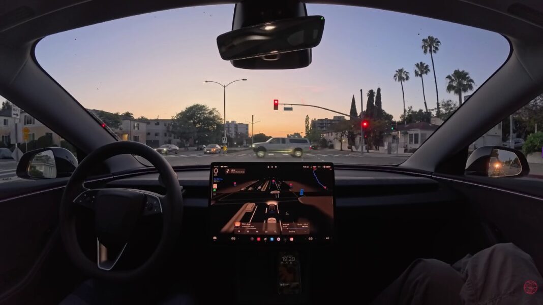 Vehículo Tesla circulando por una calle urbana, mostrando su sistema de conducción asistida.