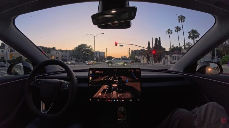 Vehículo Tesla circulando por una calle urbana, mostrando su sistema de conducción asistida.