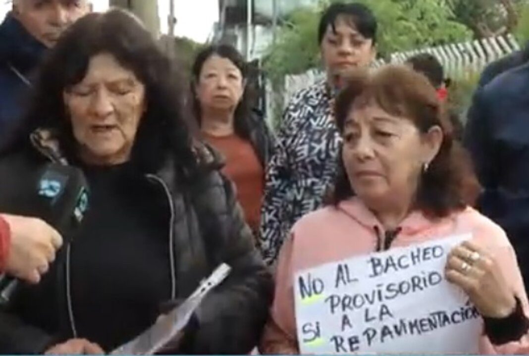 Vecinos reunidos en una calle deteriorada del barrio José Ignacio Díaz, en Córdoba, señalando los baches.
