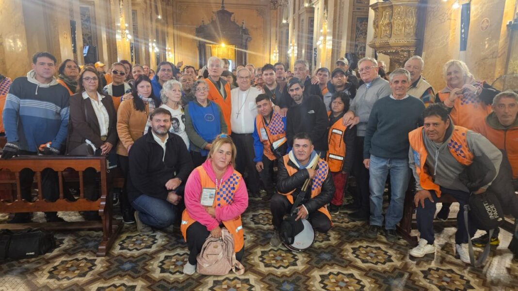 Trabajadores cuidacoches dentro de la Catedral de Córdoba junto al arzobispo Ángel Rossi